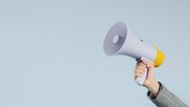 Cilvēka roka, kas tur skaļruni